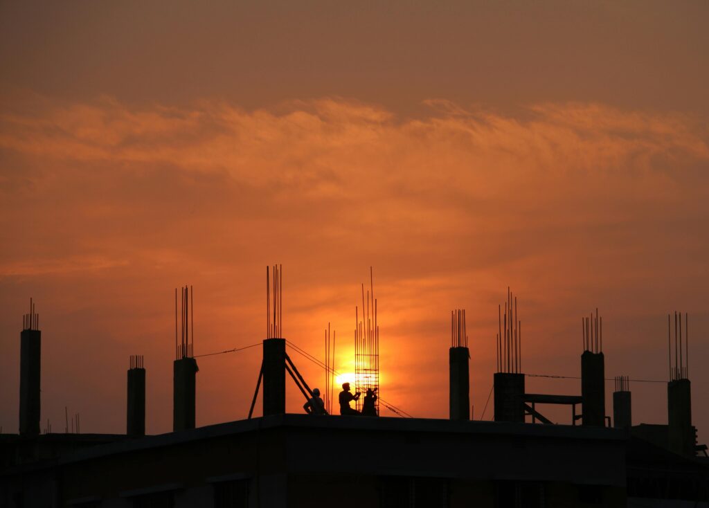 pexels photo 176342 176342 Silhouette of workers on a construction site against a vibrant sunset sky.
